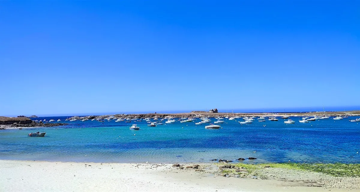 A beach in Brittany with pleasure boats on turquoise waters