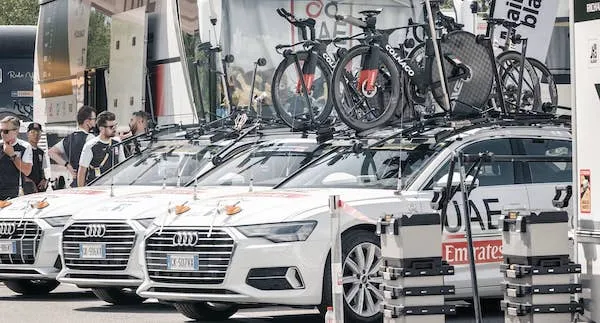 A cycling team's van with bikes on the roof in the paddock during a time trial