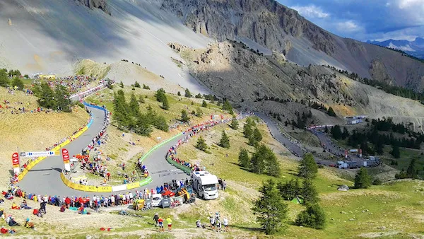 A hairpin turn on the Col d'Izoard in the Alps during the Tour de France, with crowds lining the roadside