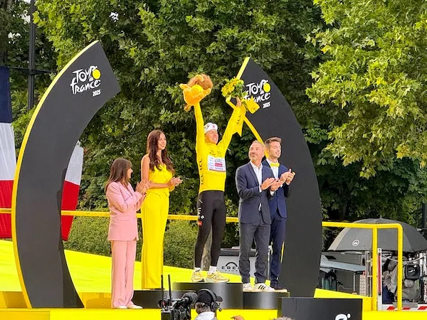Tadej Pogačar, wearing the yellow jersey, celebrates his victory on the final podium of the Tour de France on the Champs-Élysées in Paris